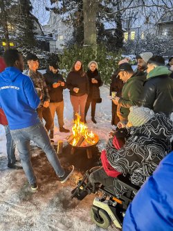 Teilnehmer tauschen sich an der wärmenden Feuerschale aus